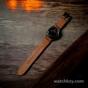Gunny Nato Light Tan 26mm with PAM 532 on wooden table in darker lighting